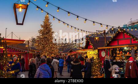 Zürich, Schweiz - 23. November 2023: Weihnachtsmarkt vor der Oper am Sechselautenplatz-Bellevue in Zürich bei Sonnenuntergang Stockfoto