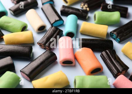 Viele leckere Süßholzbonbons auf hellblauem Hintergrund, Nahaufnahme Stockfoto