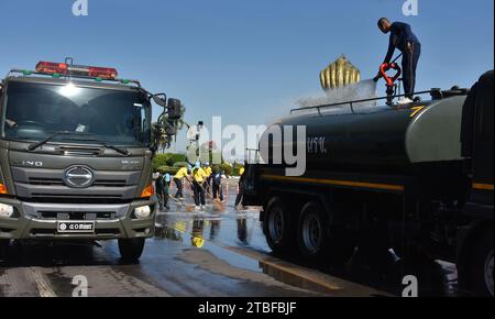 Junge Vertreter der Royal Thai Army helfen anderen bei einem nationalen Aufräumtag in Nakhon Phanom, Thailand, Südostasien. Der 5. Dezember ist ein Nationalfeiertag, da er an den Geburtstag des verstorbenen Königs Bhumibol Adulyadej, Rama 9, erinnert. Diese Veranstaltung beginnt mit einer Parade für Fotos und kurze Reden, gefolgt von allen, die Zweigbürsten und Wassertanker verwenden, um die Straßen sauber zu fegen. Der Tag wird in Thailand als Vatertag bezeichnet. Stockfoto