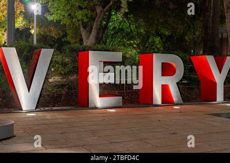 Rote und graue dreidimensionale 3D-Buchstaben, die das Wort SEHR mit einem abendlichen Outdoor-Hintergrund bilden. Stockfoto