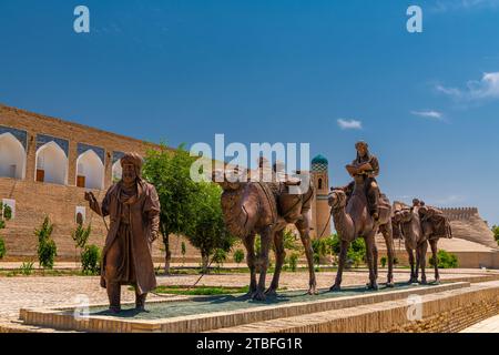 26. JUNI 2023, CHIWA, USBEKISTAN: Statuen der Kamelkarawane, die durch die alte Seidenstraße in der Altstadt von Chiwa fahren Stockfoto