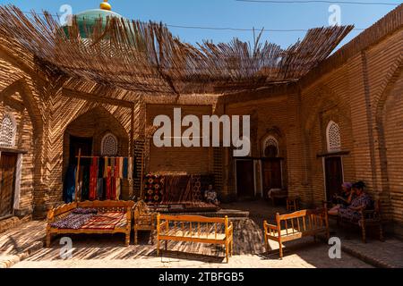 26. JUNI 2023, CHIWA, USBEKISTAN: Usbekische Frauen, die sich im Hinterhof des Hauses in Chiwa entspannen Stockfoto