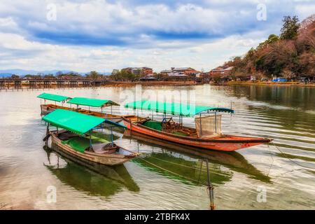 Flaches jon Boot auf dem Katsura Fluss in Kyoto Stadt Japan beliebte touristische Arashiyama Gegend mit Brücke und Damm. Stockfoto