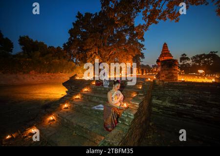 CHIANGMAI - 28. NOVEMBER 2023 : schöne asiatische Frauen, die Kerzenlicht halten, um zu Buddha in Wiang Kum kam in Chiang Mai, Thailand zu beten. Stockfoto