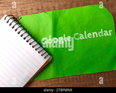 Malaysia, 31. März 2022: Notizbuch und farbiges Notizbuch mit Text Google Calendar auf hölzernem Hintergrund. Stockfoto