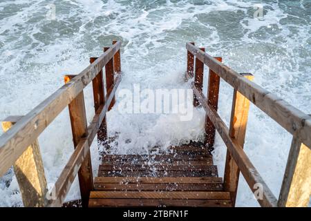 Holztreppen führen bei Flut hinunter zum Findhorn Strand. Morayshire, Schottland Stockfoto