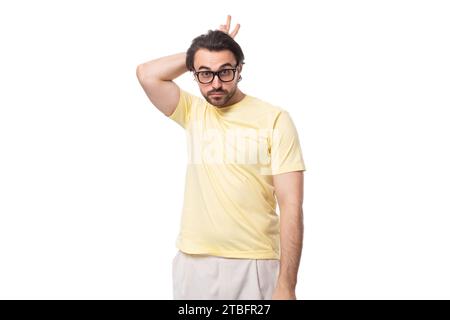 Junger kaukasischer Mann mit schwarzem Haar und Bart zeigt Grimasse Stockfoto