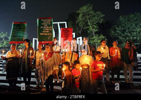 Dhaka, Bangladesch. Dezember 2023. Sozialaktivisten halten Kerzen, als sie gegen die Tötung von Frauen und Kindern in Gaza durch israelische Angriffe am 6. Dezember 2023 in Dhaka, Bangladesch, protestieren. Foto Habibur Rahman/ABACAPRESS.COM Credit: Abaca Press/Alamy Live News Stockfoto