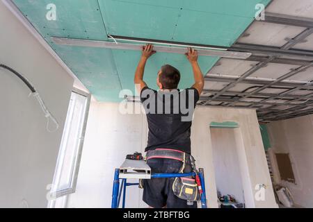 Drywall Installers. Men holding a gypsum board figured cut Stockfoto