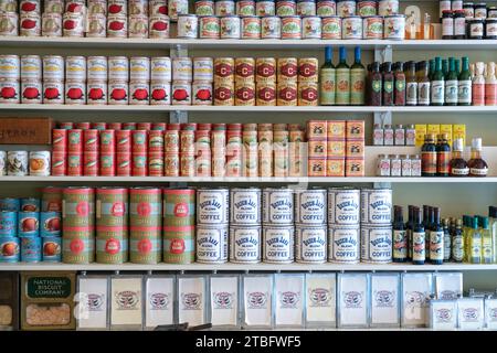 Bodentiefe Regale in einer historischen Lebensmittelschau halten Reihen von Vintage-Dosen, Flaschen, Blechdosen und Schachteln mit bunten Etiketten in Dayton, Ohio. Stockfoto