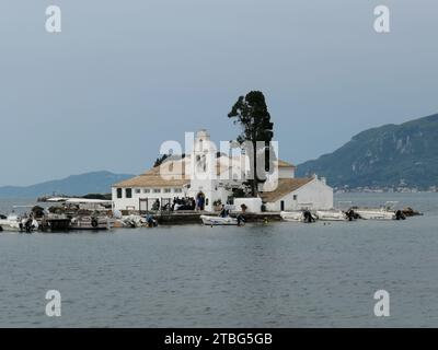 Korfu Stadt, Griechenland. Mai 2022. Touristen stehen vor dem Kloster Vlacherna mit der kleinen Kirche Panagias Ton Vlachernon, Kirche der Jungfrau Maria, im Bezirk Kanoni der Stadt Korfu auf der Ionischen Insel Korfu in Griechenland. Das Kloster Vlacherna ist einer der meistfotografierten Orte auf Korfu. Quelle: Beate Schleep/dpa/Alamy Live News Stockfoto