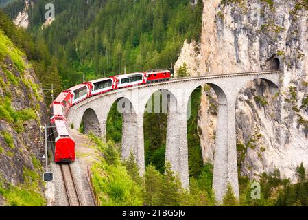 Schweizer Roter Zug auf Viadukt in den Bergen, malerische Fahrt Stockfoto