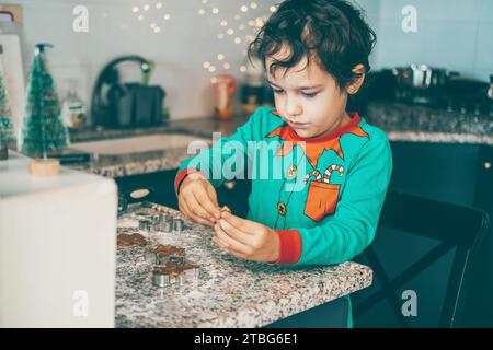 In einer gemütlichen Küche verbinden sich eine glückliche Mutter und ihr Sohn über die Weihnachtskuchenzubereitung Stockfoto