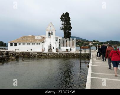 Korfu Stadt, Griechenland. Mai 2022. Touristen laufen über eine enge Fußgängerbrücke zum Kloster Vlacherna mit der kleinen Kirche Panagias Ton Vlachernon, Kirche der Jungfrau Maria, im Bezirk Kanoni der Stadt Korfu auf der Ionischen Insel Korfu in Griechenland. Das Kloster Vlacherna ist einer der meistfotografierten Orte auf Korfu. Quelle: Beate Schleep/dpa/Alamy Live News Stockfoto