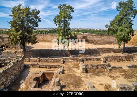 Ruinen der arabischen Festung Alcazaba in der spanischen Stadt Mérida, mit Granitmauern, Blöcken und einer Zisterne. Römische Brücke über den Fluss Guadiana. Stockfoto