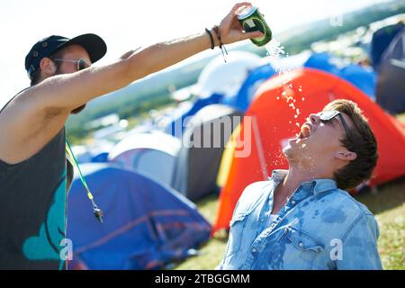 Bier, Festival oder betrunkene Freunde, die zusammen trinken, Alkohol trinken oder gesellschaftliche Veranstaltung im Freien. Musikkonzert im Sommer, Drinks trinken oder begeisterte Menschen Stockfoto