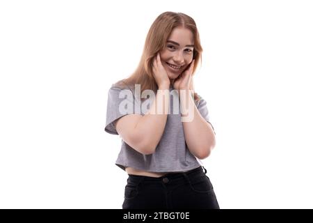 Bescheidenes Mädchen im Teenageralter mit blonden Haaren und Zahnspangen auf weißem Hintergrund Stockfoto