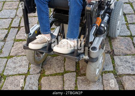 Nahaufnahme einer behinderten Person mit einem modernen elektrischen Rollstuhl Stockfoto
