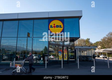 Alter Mann mit Einkaufswagen, der an der Fassade des Lidl Supermarktes in Seia, Portugal, Europa vorbeifährt Stockfoto