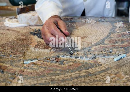 Person, die das römische Mosaik in Conimbriga, Portugal, Europa restauriert Stockfoto