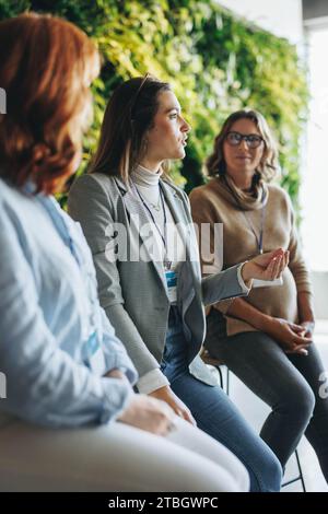 Junge Geschäftsfrauen haben während einer Podiumsdiskussion in einem Büromeeting produktiv diskutiert. Ihre Teamarbeit glänzt bei der Teilnahme an einer Konferenz Stockfoto