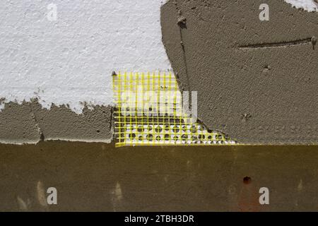 Geklebte Ecke, perforiert mit einem Gitter an der Fassade des Hauses Stockfoto