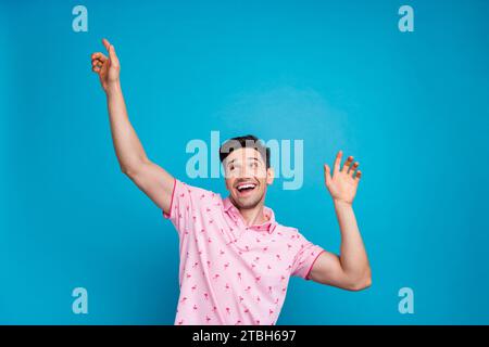 Porträt des überfröhlichen jungen Mannes gute Stimmung tanzend Party isoliert auf blauem Hintergrund Stockfoto