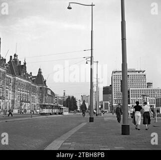 Ein Straßenblick auf Rotterdam im Jahr 1955 – das wurde mit Blick nach Süden fotografiert, während die Menschen den Coolsingel hinuntergingen. Eine Straßenbahn hält an einer Straßenbahnhaltestelle – Stadhuisplein befindet sich auf der rechten Seite. Auf der linken Seite befindet sich Stadhuis Rotterdam. Das moderne Gebäude (rechts) ist Holbeinhuis – ein Vintage-Foto aus den 1950er Jahren. Stockfoto