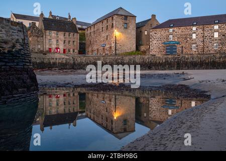 Portsoy historischer Hafen nach Sonnenaufgang bei Ebbe. Aberdeenshire, Schottland Stockfoto