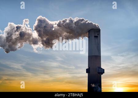 Ein Blick auf eine Industrieanlage mit einem großen Schornstein, der Rauch in den Himmel ausstrahlt Stockfoto