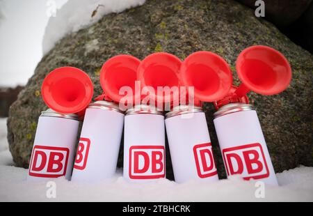 Fehmarn, Deutschland. Dezember 2023. Horndosen mit dem DB-Logo stehen neben dem Veranstaltungsort vor einer Zeremonie der Deutschen Bahn. Die Deutsche Bahn gibt auf Fehmarn das Signal für den Bau der Eisenbahnverbindung zum geplanten Ostseetunnel. Die 88 Kilometer lange Bahnstrecke zwischen Puttgarden und Lübeck wird den geplanten Straßen- und Eisenbahntunnel ab 2029 an das deutsche Eisenbahnnetz anschließen. Quelle: Christian Charisius/dpa/Alamy Live News Stockfoto