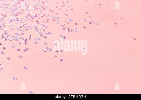 Silbernes Kristallkonfetti auf rosa Hintergrund. Selektiver Fokus. Platz für Text. Stockfoto