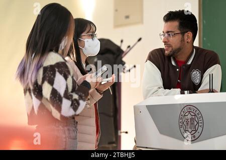 (231207) -- TIANJIN, 7. Dezember 2023 (Xinhua) -- Raydis Franco (1. R) spricht mit Studenten während einer Klassenpause in der Nankai-Universität, nordchinesischer Provinz Tianjin, 4. Dezember 2023. Raydis Franco aus Venezuela und Santiago ARAG¨®n aus Spanien sind beide Spanischlehrer, die an der Hochschule für Fremdsprachen der Nankai-Universität im nordchinesischen Tianjin arbeiten. Von der chinesischen Kultur angezogen, begannen sie, Chinas Quergespräch auf Spanisch zu lernen und zu führen. Franco fungiert als Dougen, ein Hauptredner, der Schlagzeilen und Witze liefert, während ARAG¨®n die Rolle des Penggen übernimmt, eines unterstützenden Schauspielers, der reactioniert Stockfoto