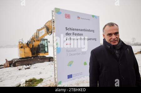 Fehmarn, Deutschland. Dezember 2023. Berthold Huber, Mitglied des Vorstands Infrastruktur der Deutschen Bahn AG, steht bei einer Festveranstaltung der Deutschen Bahn vor einem Schild mit der Aufschrift „Eisenbahnverbindung zur festen Fehmarnbelt-Querung“. Mit der Zeremonie gab die Deutsche Bahn auf Fehmarn das Signal für den Bau der Eisenbahnverbindung zum geplanten Ostseetunnel. Die 88 Kilometer lange Bahnstrecke zwischen Puttgarden und Lübeck wird den geplanten Straßen- und Eisenbahntunnel ab 2029 an das deutsche Eisenbahnnetz anschließen. Quelle: Christian Charisius/dpa/Alamy Live News Stockfoto