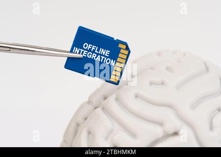 Ein Mann steckt eine Speicherkarte in sein Gehirn mit der Inschrift "Offline Integration". Geschäfts- und Technologiekonzept. Stockfoto