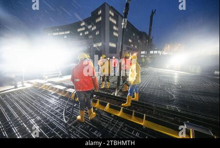 Stuttgart, Deutschland. November 2023. Arbeiter, die im Rahmen des milliardenschweren Eisenbahnprojekts Stuttgart 21 den letzten Abschnitt des Daches des neuen unterirdischen Bahnhofs betonieren. Das Bahnprojekt Stuttgart 21 wird wieder teurer. Wie die Deutsche Presse-Agentur am Donnerstag aus Aufsichtsratskreisen erfuhr, werden die Kosten um 1,7 Milliarden Euro auf rund 11 Milliarden Euro steigen. Der Hauptgrund dafür seien die gestiegenen Baukosten. Quelle: Bernd Weißbrod/dpa/Alamy Live News Stockfoto