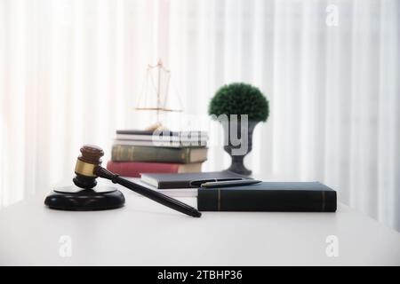 Holzgabel und Bücher auf dem Tisch im Anwaltsbüro. Stockfoto