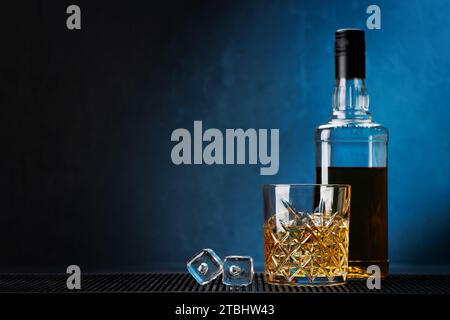 Whiskey mit kristallklaren Eiswürfeln. Glas und Flasche. Mit Kopierraum Stockfoto