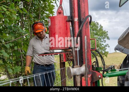 Zäune mit Werkzeugen seines Gewerbes, die einen Viehzaun aus Drahtgeflecht errichten. Co. Durham, Großbritannien. Stockfoto