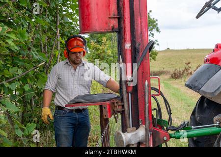 Zäune mit Werkzeugen seines Gewerbes, die einen Viehzaun aus Drahtgeflecht errichten. Co. Durham, Großbritannien. Stockfoto