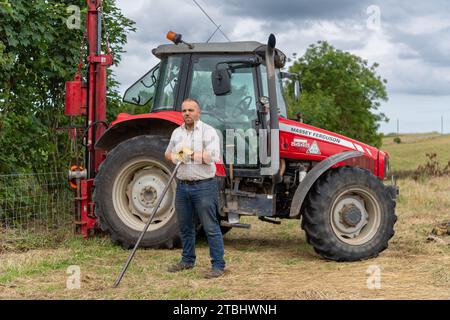 Zaununternehmer mit Werkzeugen seines Gewerbes, die einen Viehzaun aus Drahtgeflecht errichten. Co. Durham, Großbritannien. Stockfoto