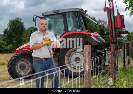 Zaununternehmer mit Werkzeugen seines Gewerbes, die einen Viehzaun aus Drahtgeflecht errichten. Co. Durham, Großbritannien. Stockfoto