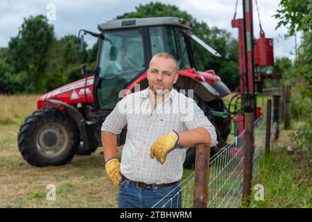 Zaununternehmer mit Werkzeugen seines Gewerbes, die einen Viehzaun aus Drahtgeflecht errichten. Co. Durham, Großbritannien. Stockfoto