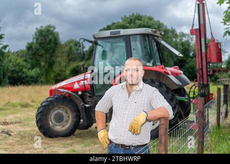 Zaununternehmer mit Werkzeugen seines Gewerbes, die einen Viehzaun aus Drahtgeflecht errichten. Co. Durham, Großbritannien. Stockfoto