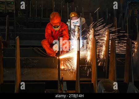 (231207) -- NANJING, 7. Dezember 2023 (Xinhua) -- Arbeiter schweißen in einer Werkstatt von Jiangsu Yangzi Xinfu Shipbuilding Co., Ltd. In Taixing, ostchinesischer Provinz Jiangsu, 5. Dezember 2023. In den ersten zehn Monaten des Jahres 2023 hat China seine Spitzenposition auf dem globalen Schiffbaumarkt mit einem starken Wachstum sowohl bei der Produktion als auch bei den Auftragseingängen beibehalten, wie Branchendaten zeigen. Die Schiffbauproduktion des Landes stieg von Januar bis Oktober um 12 Prozent auf 34,56 Millionen Tonnen Tragfähigkeit (dwt) und macht laut Daten der China Association of the 49,7 Prozent der weltweiten Gesamtmenge aus Stockfoto