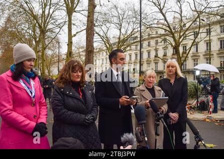 London, Großbritannien. Dezember 2023. Aamer Anwar (Mitte), leitender Anwalt für die schottischen COVID-19-Hinterbliebenen und Familienmitglieder geben Erklärungen vor den Medien ab. Demonstranten und Hinterbliebene versammelten sich vor dem COVID-19-Untersuchungszentrum, als der ehemalige Premierminister Boris Johnson am zweiten Tag aussagte. Quelle: SOPA Images Limited/Alamy Live News Stockfoto