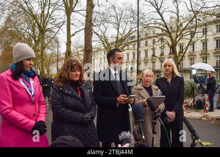 London, Großbritannien. Dezember 2023. Aamer Anwar (Mitte), leitender Anwalt für die schottischen COVID-19-Hinterbliebenen und Familienmitglieder geben Erklärungen vor den Medien ab. Demonstranten und Hinterbliebene versammelten sich vor dem COVID-19-Untersuchungszentrum, als der ehemalige Premierminister Boris Johnson am zweiten Tag aussagte. (Foto: Vuk Valcic/SOPA Images/SIPA USA) Credit: SIPA USA/Alamy Live News Stockfoto