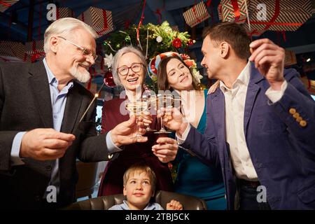 Die Familie auf der Neujahrsfeier feiert Weihnachtsglitzer und genießt Champagner Stockfoto
