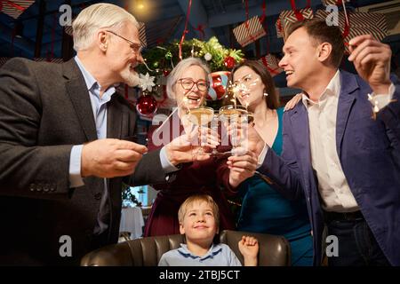 Die Familie hat Spaß mit den Glitzern, die Gläser Champagner halten, und feiert das neue Jahr Stockfoto