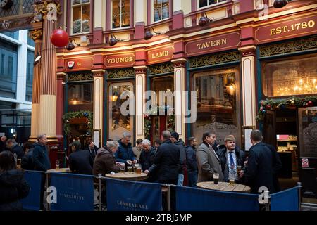 Arbeitskollegen und Kollegen genießen mittags Weihnachtsgetränke vor dem Lamb Tavern Pub in Leadenhall Market, am 7. Dezember 2023 in der City of London, England. Stockfoto